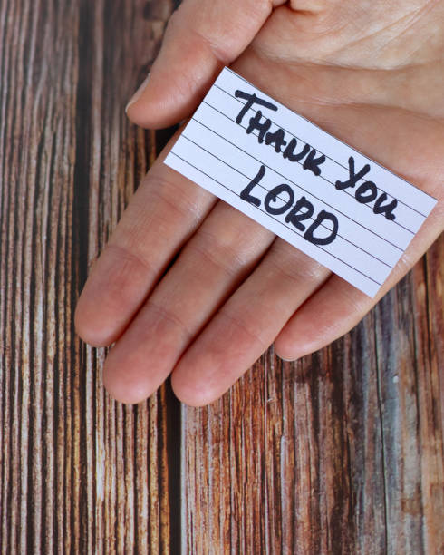 istock Hand holding a note with handwritten text: Thank You LORD over wooden table, vertical shot 1452587733