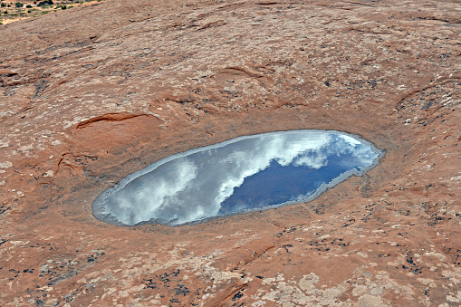 Clouds and Sky Reflected in a Desert Pool in Canyonlands National Park in Utah