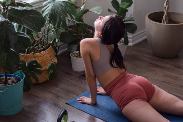 istock Young woman practicing yoga at home 1452593415