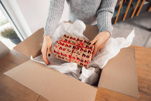 istock A woman wraps a Christmas present in a cardboard box 1452595724