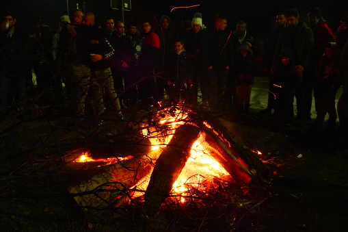 Sremska Mitrovica, January 6, 2022 Burning of the sacred oak tree at the stake in front of a crowd of people. Celebrating Christian Orthodox Christmas. Sparks fly to the believing parishioners