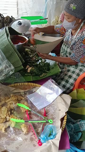 an old lady selling traditional Javanese food called Pecel