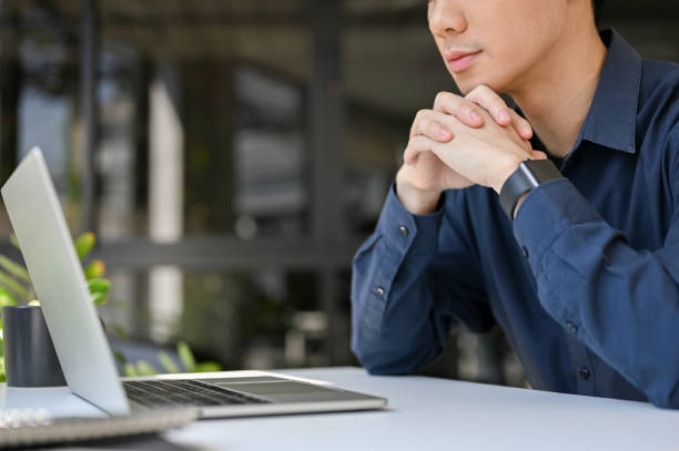 istock Focused and thoughtful young Asian businessman pensively thinking about his project 1452611491