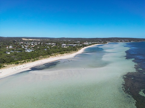 An Aerial view of a shoreline of turquoise water under blue sky