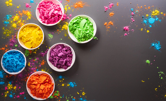 Happy Holi decoration, the indian festival.Top view of colorful holi powder on dark background.