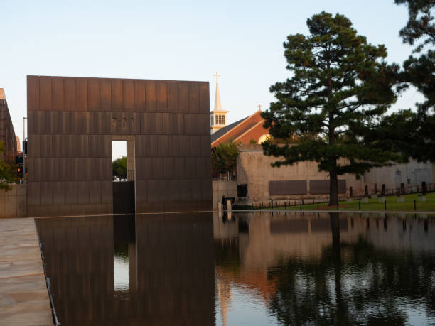 オクラホマ州のオクラホマシティ国立記念博物��館の反射プールに映る東のローアングルビューまたは9:01の時間のゲート - oklahoma city oklahoma city national memorial oklahoma famous place ストックフォトと画像