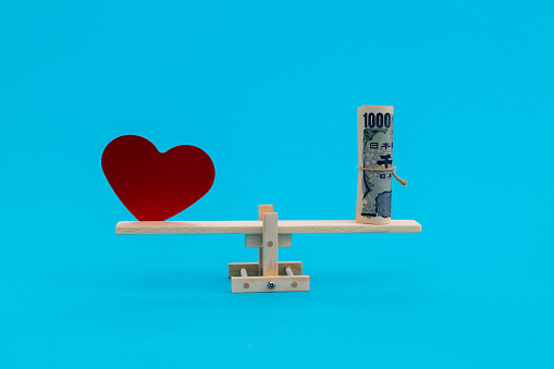 Seesaw with red heart and Japanese Yen.