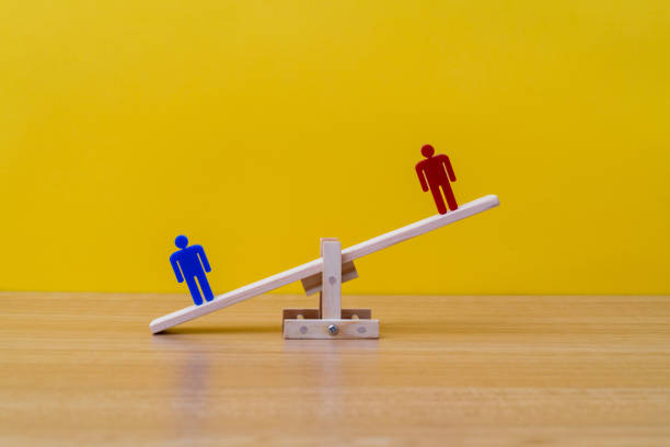 istock Human figures on wooden seesaw 1452624288