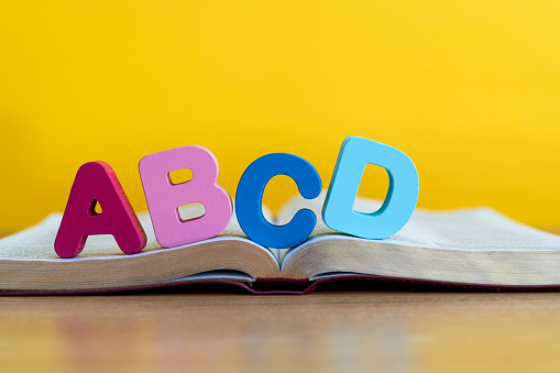 Wooden letters ABCD on the book.