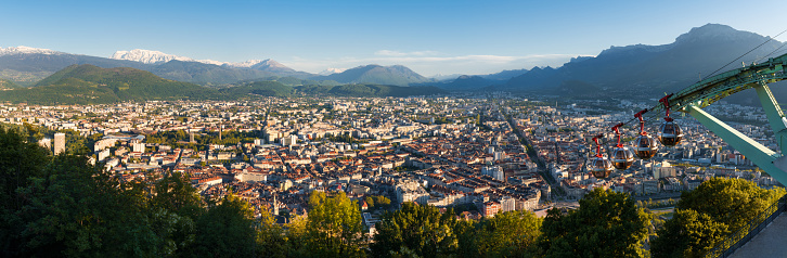 Panoramic skyline of the city of Grenoble at sunset with cable cars of Fort de la Bastille. Summer in Isere, Rhone-Alpes region, France
