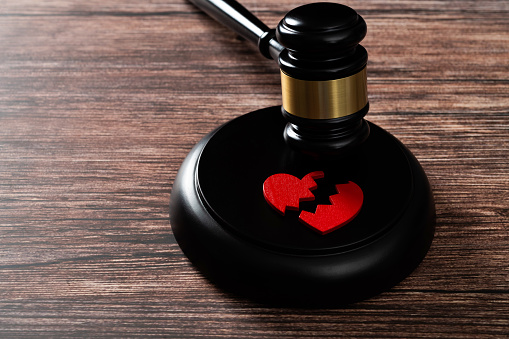 Gavel with a broken heart on the table.