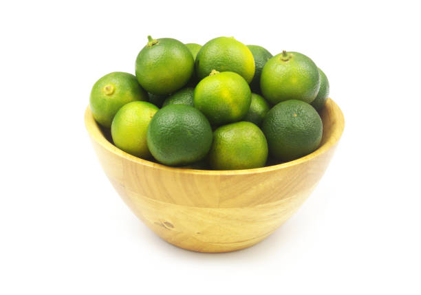 istock Fresh limes in wooden bowl isolated on white 1452627416