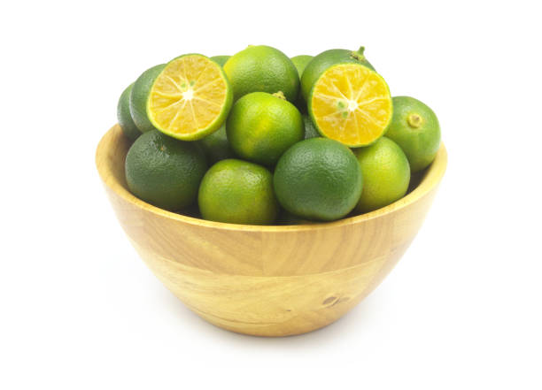 istock Fresh limes in wooden bowl isolated on white 1452627419