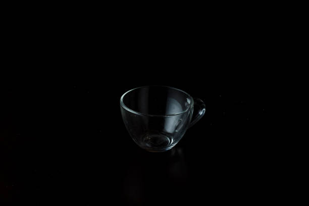 transparent glass cup on a dark background. empty cup on the table.