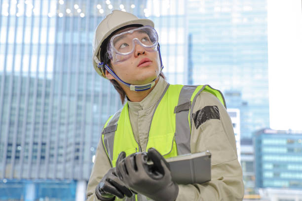 trabalhador da construção civil usando um tablet e olhando para cima - computer engineer blueprint architect - fotografias e filmes do acervo