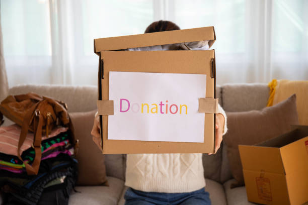 istock Girl puts donate clothes in a box. 1452633724