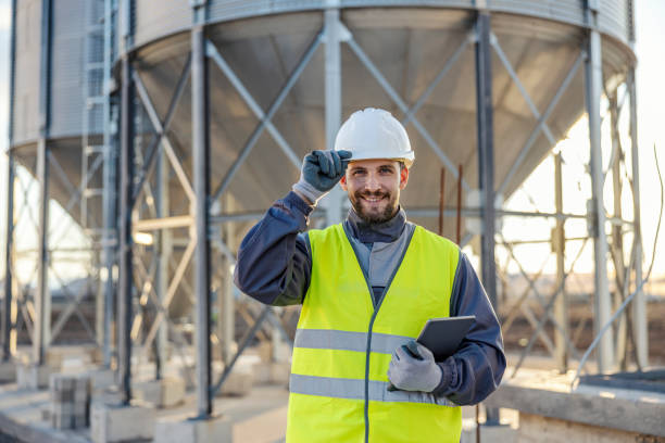 istock A industry supervisor is holding tablet in his hands and greeting while standing in front of the silos full of supplies. 1452634278