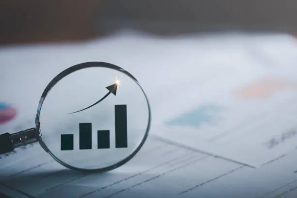 Photo of Magnifying glass showing business growth graph ,concept of progress in development, financial efficiency and investment with business strategy for goals and opportunities in the industry future