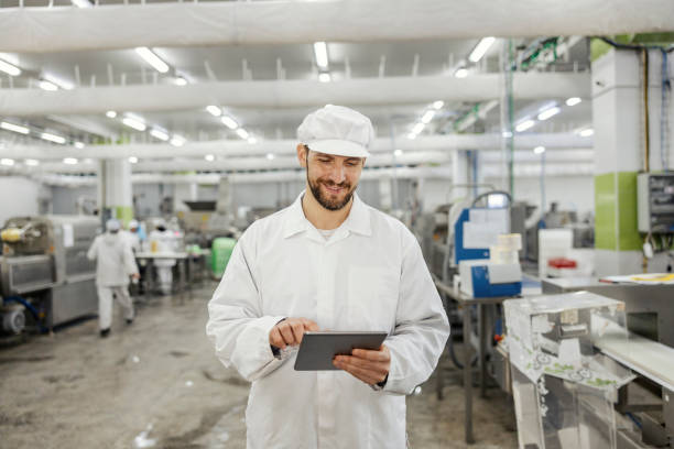 istock A happy meat industry supervisor is scrolling on a tablet and smiling at it. 1452634559