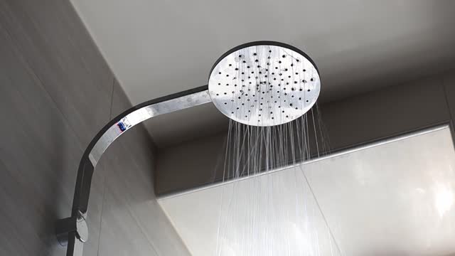 Flowing water from the shower head in the bathroom.