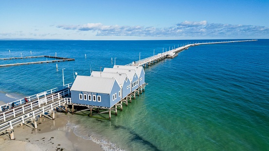 Busselton J, Australia – December 03, 2022: A scenic view of Busselton Jetty with blue cottages near the beach in Busselton, Australia