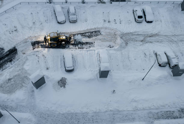 istock Tractor loader machine uploading dirty snow into dump truck. 1452641846