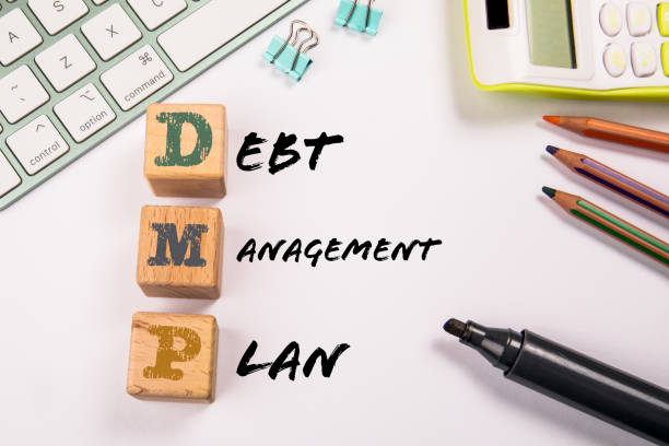 istock DMP - Debt Management Plan. Wooden blocks on a white office table 1452643230