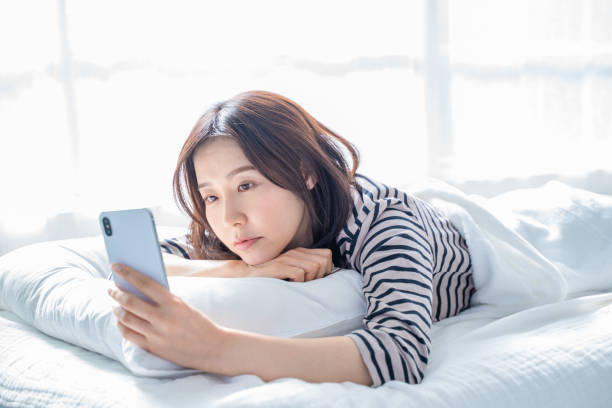 istock A woman falling asleep staring at a smartphone screen in bed. 1452643325