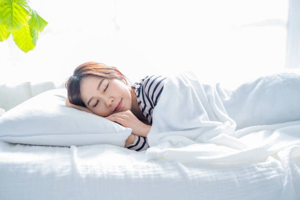 istock A woman sleeping on a bed in a bright simple room. 1452643375
