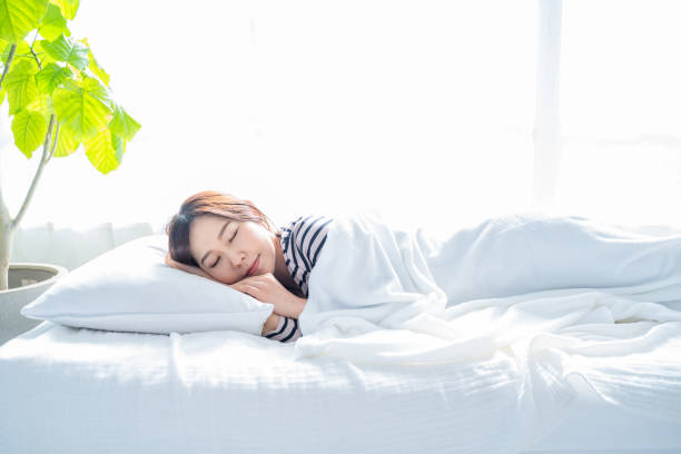 istock A woman sleeping on a bed in a bright simple room. 1452643376