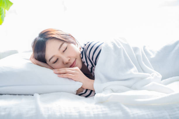 istock A woman sleeping on a bed in a bright simple room. 1452643380