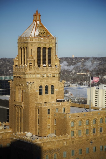 A vertical shot of the Plummer Building surrounded by the snow and ills in Rochester, Minnesota