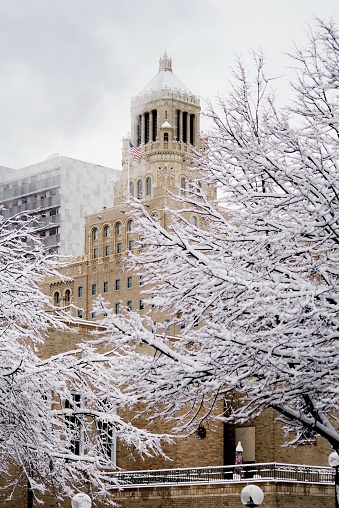 A vertical shot of the Plummer Building covered in the snow in the daylight in Rochester, Minnesota