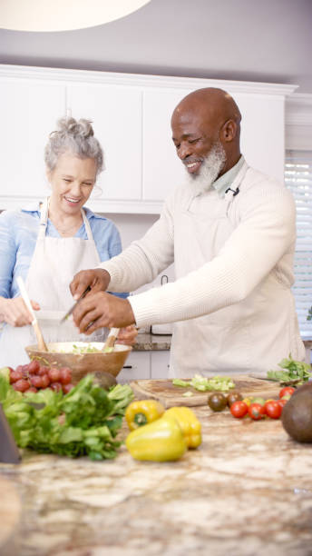 istock Cooking, food or old couple in kitchen with teamwork, collaboration or freedom helping create a healthy vegan meal. Vegetables, elderly black man and senior woman in a happy interracial marriage 1452647869