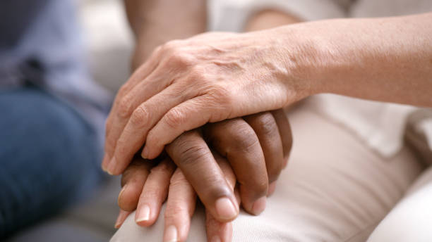 istock Holding hands, support and couple with empathy, trust and helping for mental health problem, counseling or therapy zoom. Diversity people love, care and hand holding for depression, death or bad news 1452648142