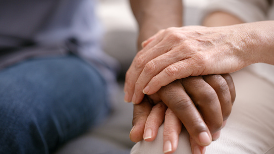 Senior couple holding hands, love and support, trust and care in retirement together. Closeup of elderly, old and diverse people, hand holding and hope, empathy and solidarity, kindness and gratitude