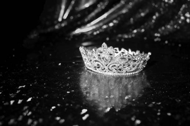 istock Royal crown on luxury satin, sparkle fabric background. Black and white. 1452651758