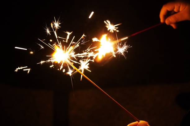 istock Handheld spark fireworks held by a child outdoors at night 1452654204