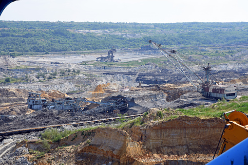 Bucket-wheel excavator during excavation at the surface mine. Huge excavator on open pit mine.