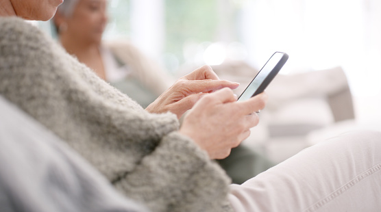 Social media, phone and senior woman hands typing, chatting or texting a message online for communication. Social network, digital or elderly user searching or scrolling on a retirement homes website