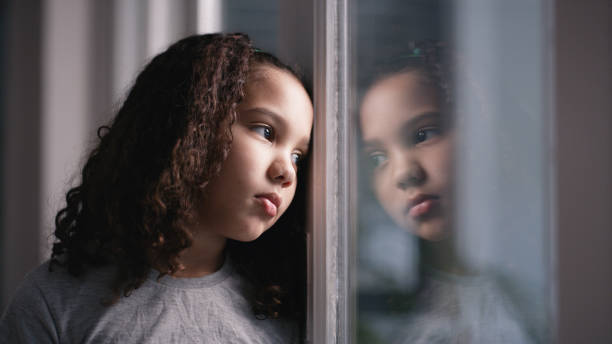 salud mental, niña y ventana para triste, pensante y deprimido en casa. depresión, niño negro e infeliz con el estrés, ansiedad y frustrado con el sufrimiento, decepcionado y adoptivo de una niña. - child sadness little girls thinking fotografías e imágenes de stock