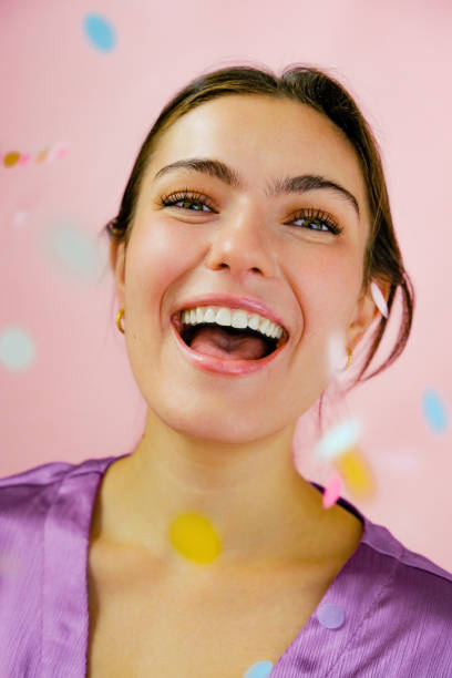 istock Young woman smiling with confetti 1452664153