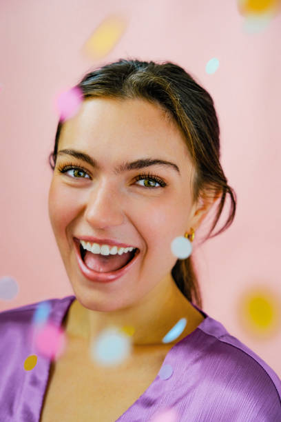 istock Young woman smiling with confetti 1452664154