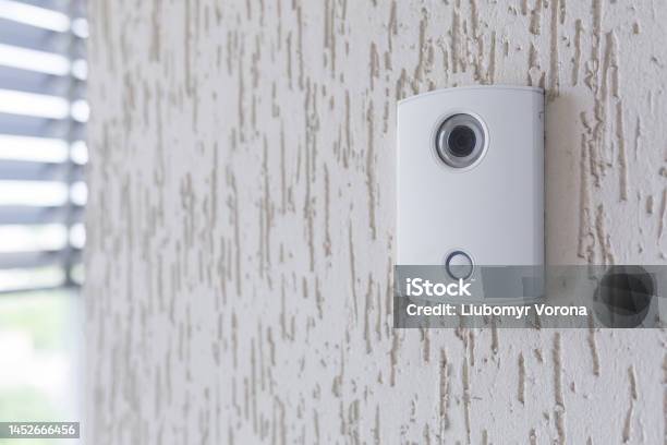 A White Incoming Electronic Doorbell With A Camera On The Wall Of The Building Office Stock Photo - Download Image Now