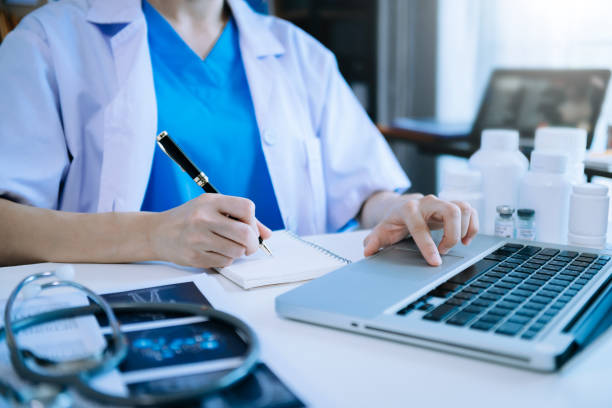 istock Medical technology concept. Doctor working with mobile phone and stethoscope and digital tablet laptop in modern office at hospital in morning light 1452666650