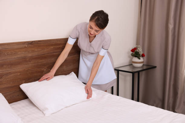 istock Beautiful chambermaid making bed in hotel room 1452666855