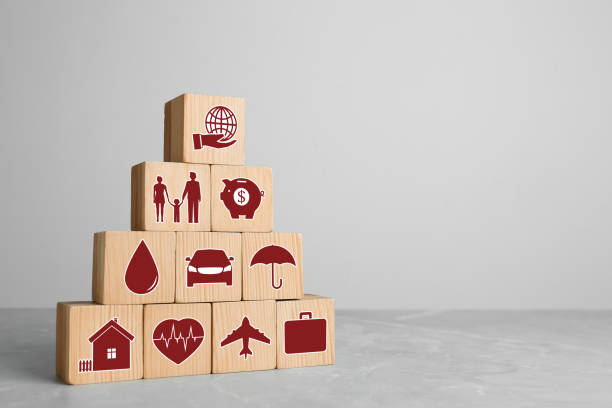 istock Wooden cubes with different icons on light grey table, space for text. Insurance concept 1452666924
