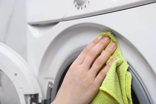 istock Woman cleaning washing machine with rag, closeup 1452667335
