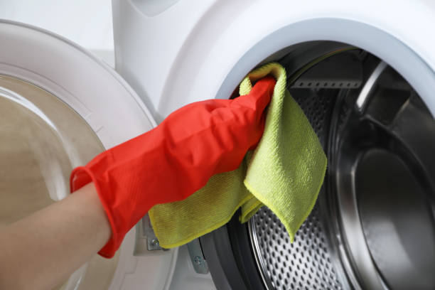 istock Woman cleaning washing machine with rag, closeup 1452667925