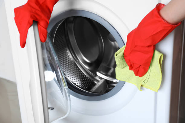 istock Woman cleaning washing machine with rag, closeup 1452668064